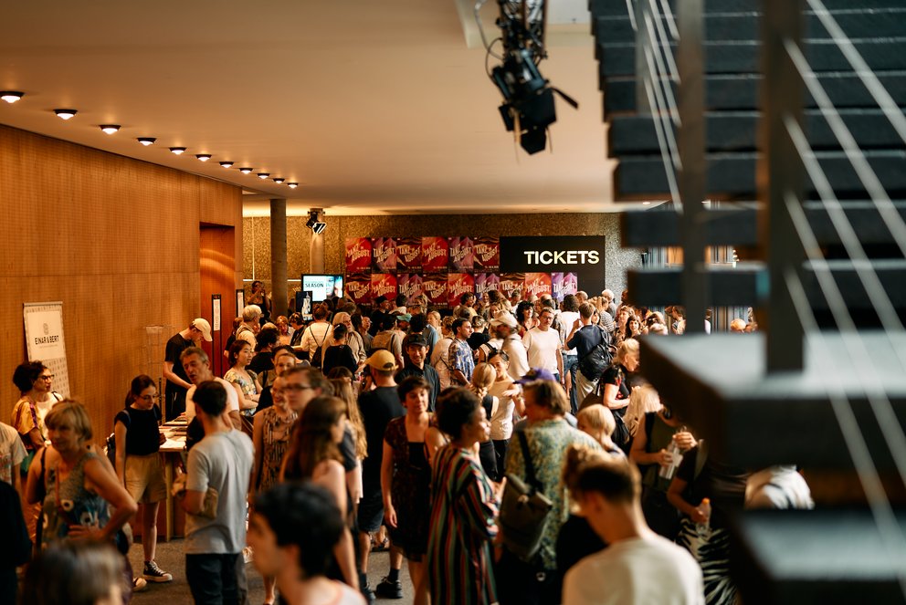 Im Haus der Berliner Festspiele sieht man Menschen versammelt.
