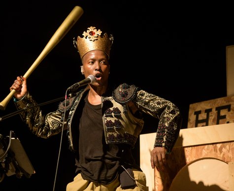 Produktionsfoto von Nora Chipaumire mit Krone und Baseballschläger aus ihrem dreiteiligen Abend