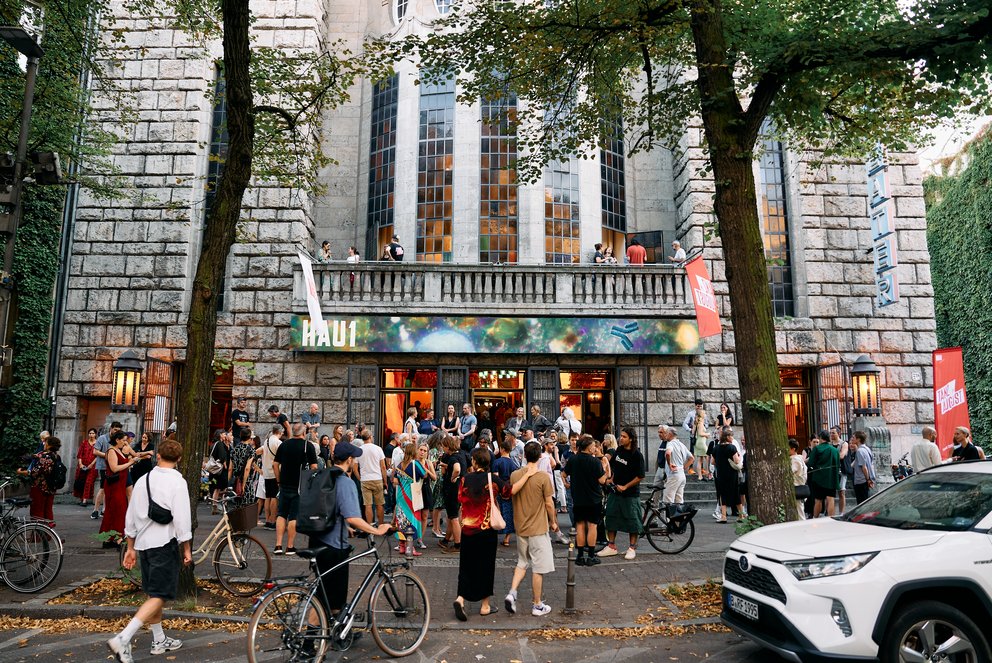 Vor dem HAU1 versammeln sich Menschen, die bereit sind, das Festival zu besuchen.