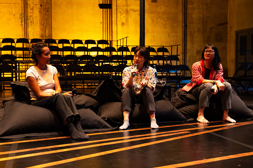 Nguyễn + Transitory wurden zusammen mit Zippora Elders während Beyond the Stage fotografiert. Im Hintergrund sind die Stühle der Tribüne zu sehen und auf dem Boden die Kupferplatten, die während der Performance erklingen.